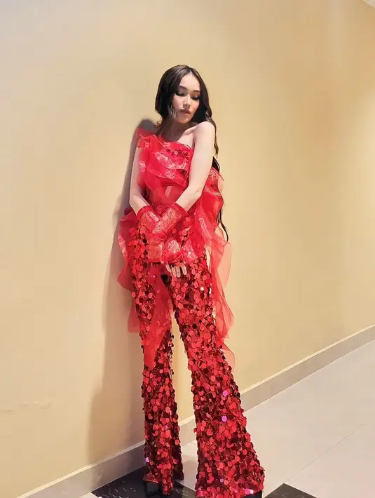 Penampilan penuh pesona lainnya dari Ayu Ting Ting dengan outfit manggung berwarna merah ini. Atasan asimetris berumbai ini dipadukan dengan sequin pants merah yang serasi. [Foto: Instagram/ayutingting92]