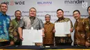 SVP Micro Development & Agent Banking Bank Mandiri Zedo Faly (ketiga kiri) dan CEO PT Crowde Membangun Bangsa (CMB) Yohanes Sugihtononugroho (ketiga kanan) usai penandatangan perjanjian kerja sama Bank Mandiri dengan PT CMB di Jakarta, Kamis (19/9/2019). (Liputan6 com/Angga Yuniar)