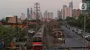 Kondisi pemukiman di pinggir rel kereta dengan latar gedung bertingkat di Jakarta, Jumat (15/12/2023). (Liputan6.com/Angga Yuniar)
