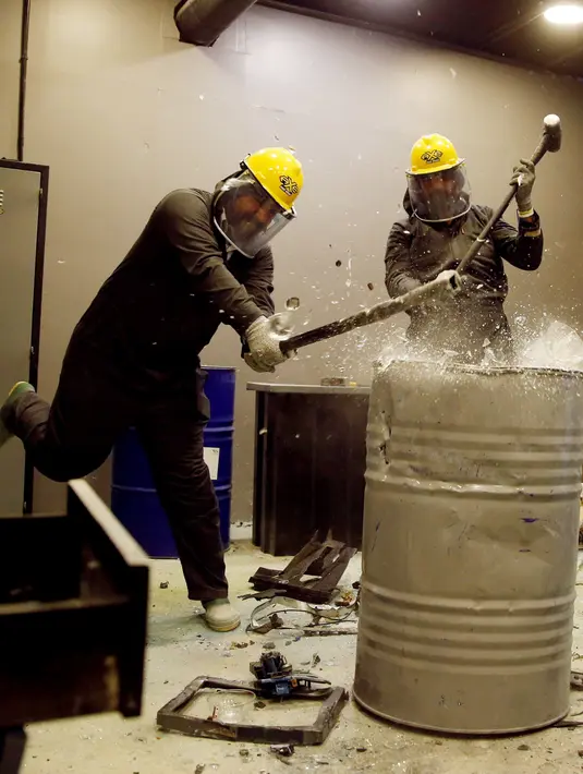 Warga Yordania menghancurkan kaca dengan palu saat melampiaskan kemarahannya di AXE Rage Room di Amman, Yordania (17/4). Mereka mengaku lega usai menghancurkan barang-barang di tempat tersebut. (Reuters/Muhammad Hamed)