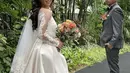 Gaun model ball gown kombinasi brokat-silk warna putih tersebut merupakan rancangan Cynthia Tan. (YouTube/Jojo and Clay).