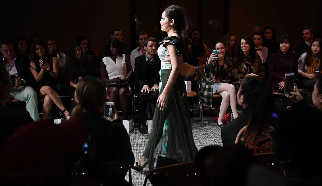 Seorang model tunanetra berpegang pada tali transparan ketika berjalan di atas catwalk pagelaran Paris Fashion Week di Paris, Rabu (5/10). (AFP PHOTO/Christophe Archambault)