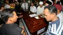 Keluarga berdiri di dekat peti jenazah Yudhistira Febbi Arianto, co pilot pesawat Aviastar yang tiba di sebuah masjid dekat Bandara Ngurah rai, Bali, Kamis (8/10). Pesawat Aviastar jatuh dan menewaskan 3 kru dan 7 penumpang. (AFP PHOTO/SONNY TUMBELAKA)