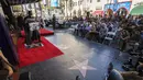 Seorang pria berkostum Batman tampak membawa foto Bob kane sang pembuat karakter Batman di Walk of Fame, Los Angeles, California, Rabu (21/10/2015). Ratusan Warga hadir dalam prosesi ini. (REUTERS/Mario Anzuoni)