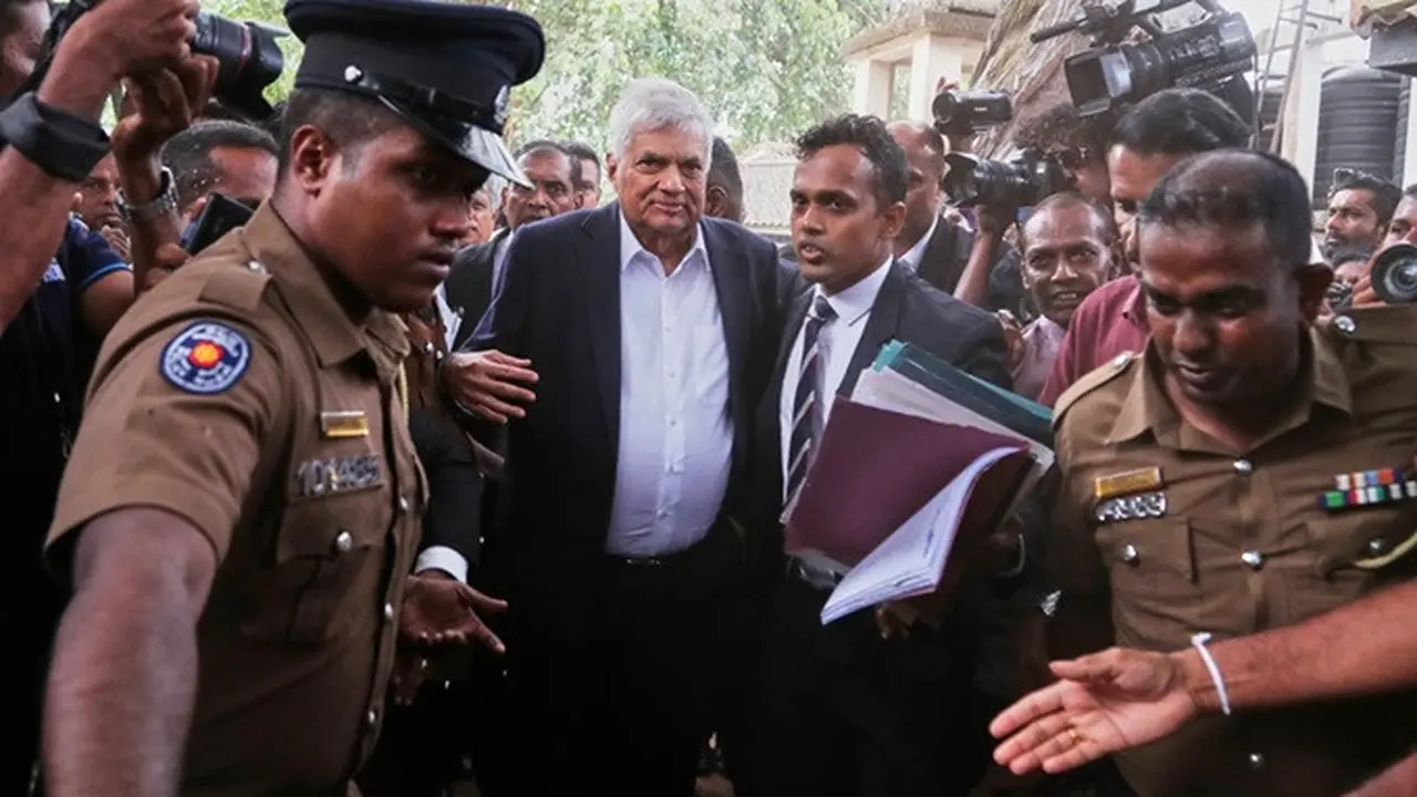 Mantan Presiden Sri Lanka Ranil Wickremesinghe (tengah) dihadirkan oleh polisi di Pengadilan Negeri Kolombo Jumat (22/8/2025).