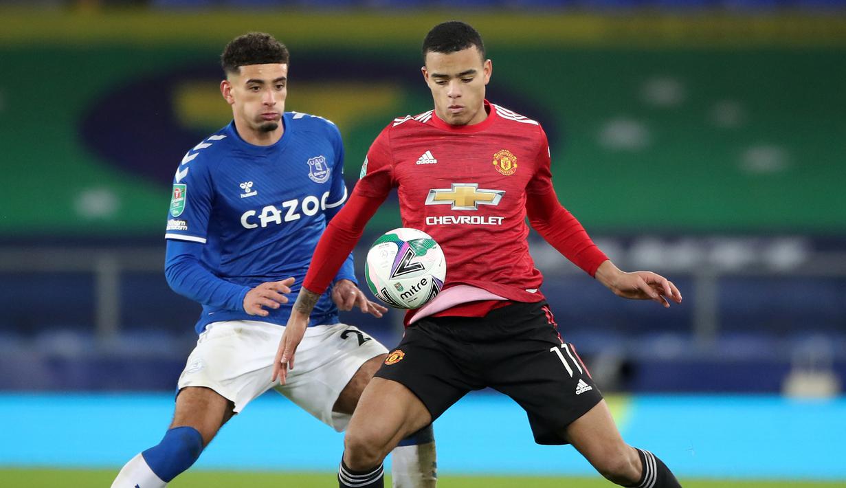 Striker Manchester United, Mason Greenwood (kanan), menguasai bola dibayangi gelandang Everton, Ben Godfrey, dalam laga perempatfinal Piala Liga Inggris Carabao Cup di Goodison park, Rabu (23/12/2020). Manchester United menang 2-0 atas Everton. (AFP/Nick Potts/Pool)