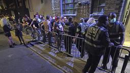 Orang-orang mengantre untuk masuk ke kelab malam Egg di London setelah pembatasan legal virus corona dicabut di Inggris pada tengah malam, Senin (19/7/2021). Ribuan anak muda berdansa semalaman di pesta 'Hari Kebebasan'. (Jonathan Brady/PA via AP)