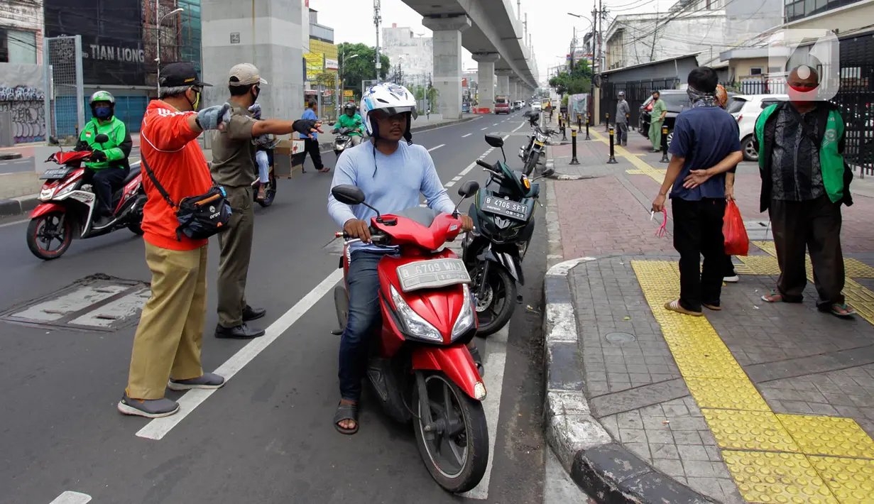 Pengendara motor pergi seusai diberi hukuman push up karena tidak memakai masker saat razia Pembatasan Sosial Berskala Besar (PSBB) di Kawasan Jalan Fatmawati, Jakarta, Selasa (28/4/2020). Penertiban terkait pelaksanaan PSBB Jakarta dan memutus rantai penyebaran COVID 19. (merdeka.com/Imam Buhori)