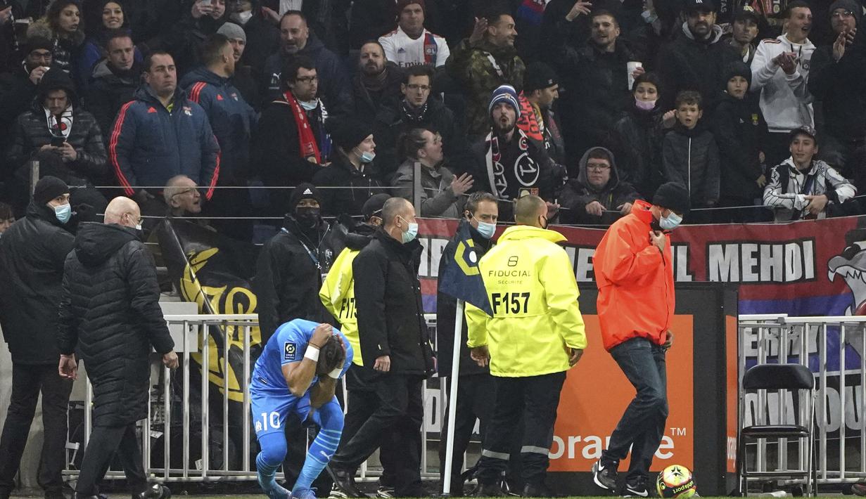 Payet pun langsung memegang bagian kepalanya yang terkena botol. (AP Photo/Laurent Cipriani)