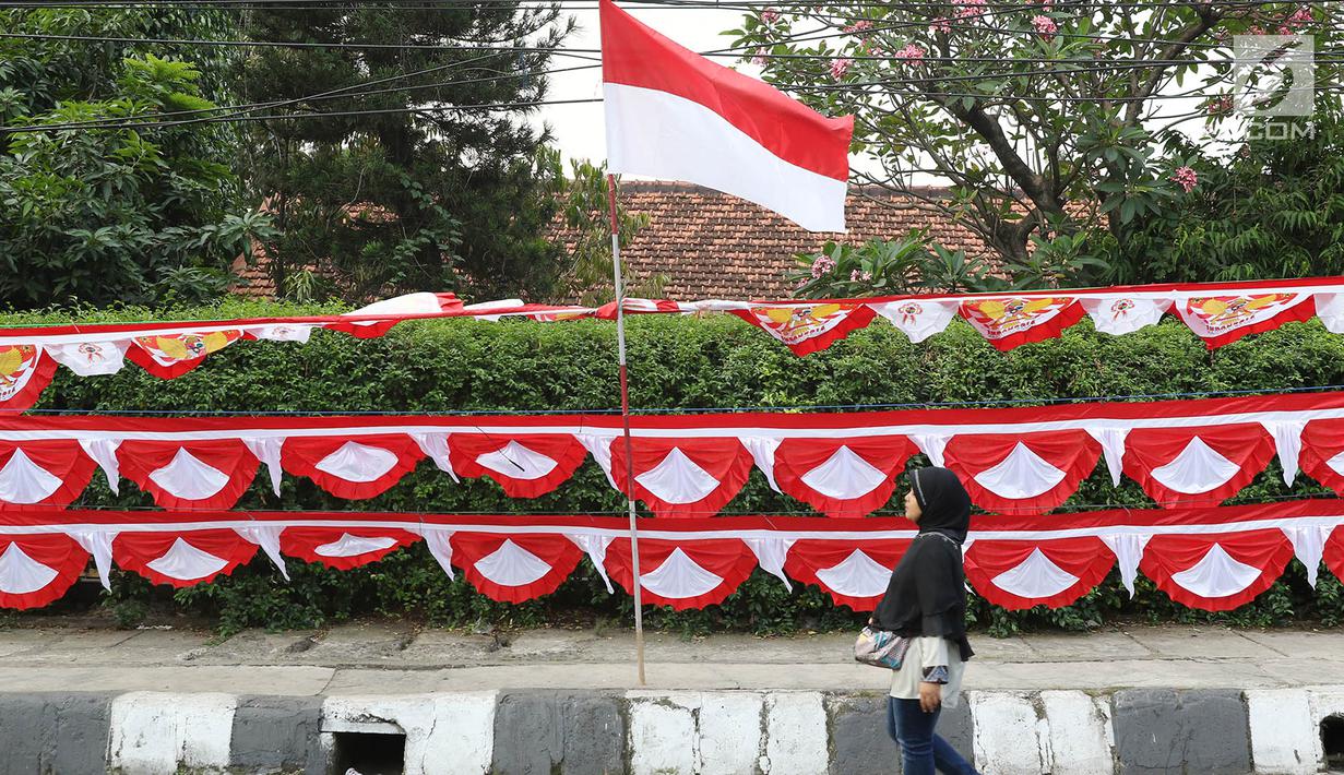 Warga melintas di depan bendera dan aksesori kemerdekaan RI, Jakarta Selatan, Selasa (1/8). Penjualan bendera serta aksesori kemerdekaan ditawarkan dengan harga bervariasi, mulai Rp10ribu hingga Rp250ribu. (Liputan6.com/Immanuel Antonius)