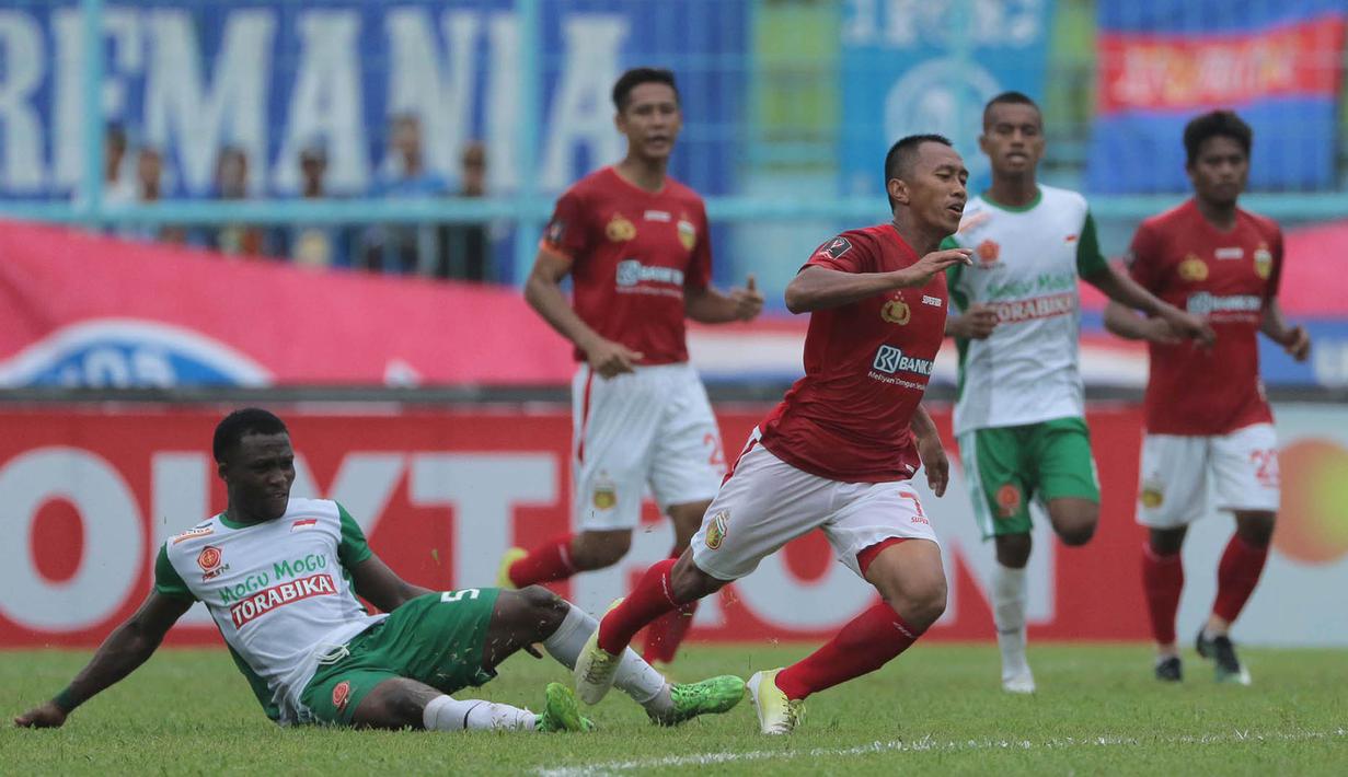 Gelandang PS TNI, Ibrahim Conteh, melakukan tekel keras saat melawan Bhayangkara FC pada laga Piala Presiden 2017 di Stadion Kanjuruhan, Malang, Sabtu (11/7/2017). Bhayangkara FC menang 2-1 atas PS TNI.(Bola.com/Reza Bachtiar)