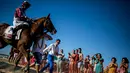 Penonton menyaksikan lomba pacuan kuda di tepi pantai di Sanlucar de Barrameda, Spanyol pada 11 Agustus 2019. Balap kuda di tepi pantai ini merupakan acara tahunan yang telag berlangsung selama lebih dari 140 tahun. (AP Photo/Javier Fergo)