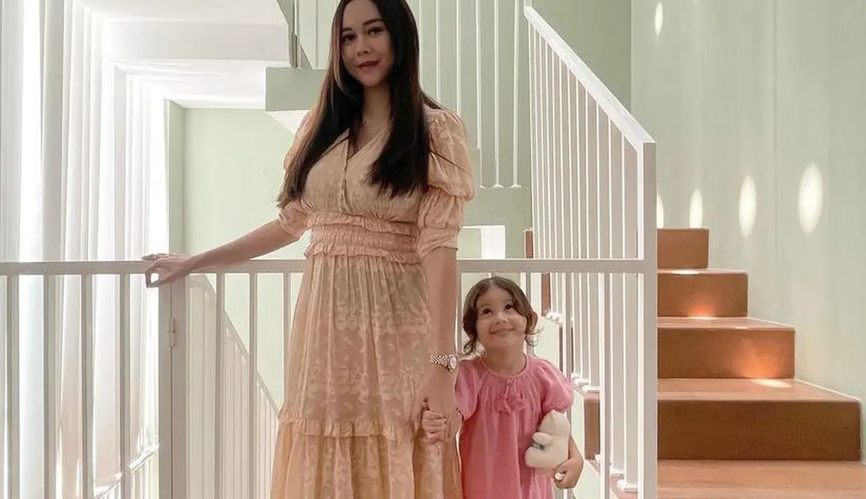 <p>Begitu pula dengan gaya busananya yang mirip sang mama. Dalam potret ini terlihat keduanya tampil serasi mengenakan dress. (Instagram/aurakasih).</p>
