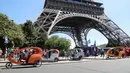Sejumlah pengendara becak menunggu wisatawan di sekitaran Menara Eiffel, Kota Paris, Prancis,  (7/7). Menurut media setempat, kemunculan becak ini membuat para sopir taksi memiliki saingan. (AFP Photo/Jacques Demarthon)