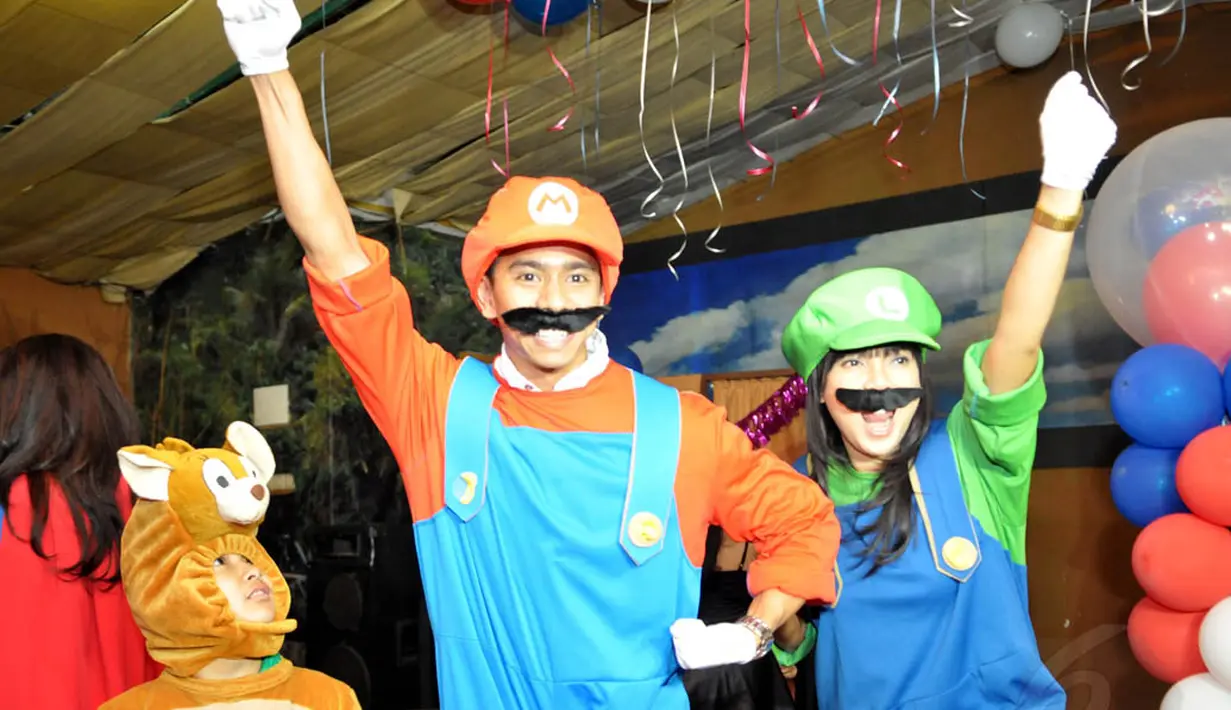 Pasangan Fitri Tropica dan Irfan Hanafi  berkostum sepasang sahabat tukang pipa, Mario dan Luigi di acara ulang tahun kejutan untuk manajer Fitrop di Inbek Manajemen, Jakarta, Selasa(22/7/14). (Liputan6.com/Panji Diksana)