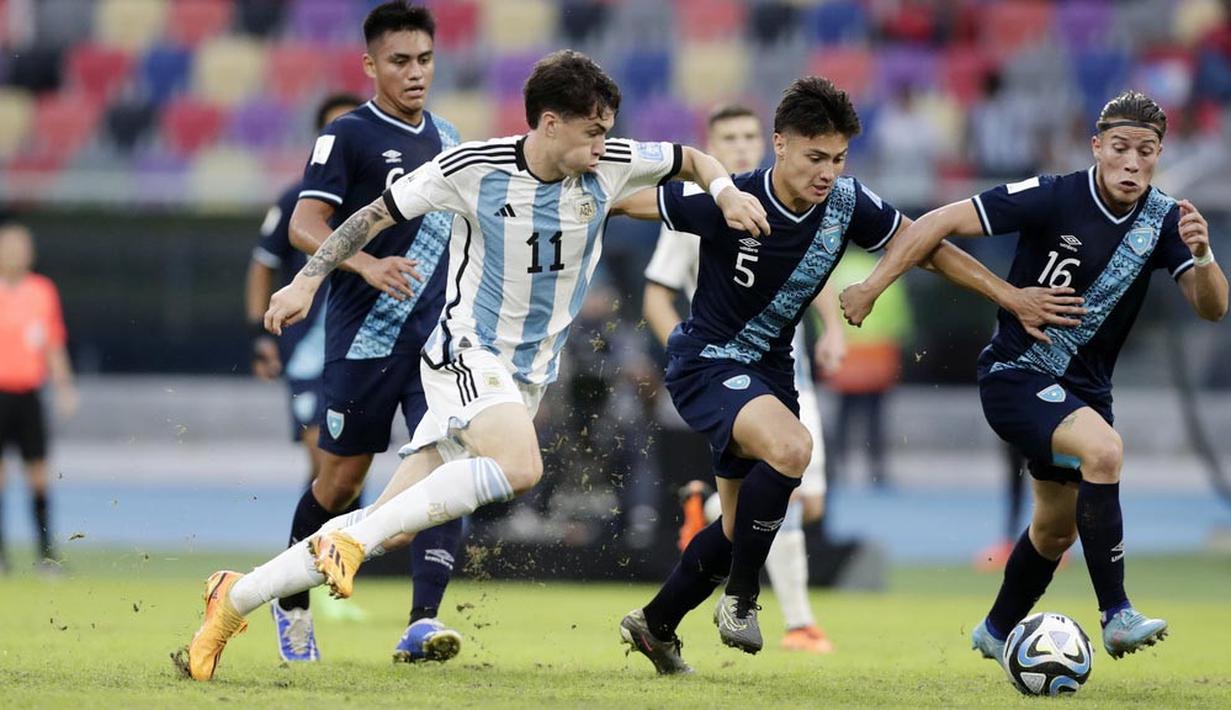 Pemian Timnas Argentina U-20, Matias Soule, berusaha melewati pemain Guatemala, Arian Recinos, pada laga Grup A Piala Dunia U-20 2023 di Estadio Unico Madre de Ciudades, Rabu (24/5/2023). Argentina membungkam Guatemala tiga gol tanpa balas. (AP Photo/Nicolas Aguilera)