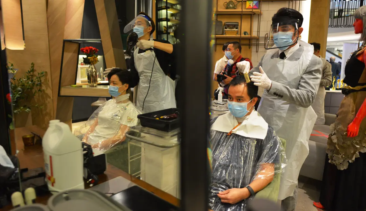 Para barber memangkas rambut pelanggan di sebuah tempat pangkas rambut di Kuala Lumpur, Juni 2020. Setelah hampir tiga bulan masa lockdown, pemerintah Malaysia melakukan pelonggaran sebagai upaya menghidupkan kembali perekonomian yang sempat terpukul akibat pandemi Covid-19. (Xinhua/Zhu Wei)