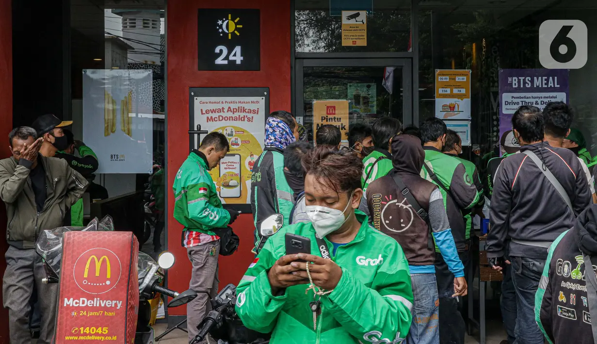 Sejumlah pengemudi ojek online berkerumun saat antre mengambil pesanan di gerai cepat saji McDonald's Raden Saleh, Jakarta, Rabu (9/6/2021). BTS Meal merupakan menu kolaborasi boyband asal Korea, BTS, dengan McDonald's yang hadir di 50 negara termasuk Indonesia. (Liputan6.com/Faizal Fanani)