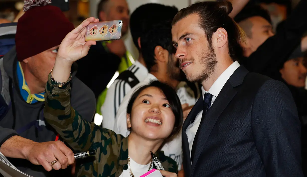 Penyerang Real Madrid Gareth Bale saat berfoto bersama fans di Bandara Manchester, Inggris, (25/4). Real Madrid akan menjalani semifinal leg pertama liga Champion melawan Manchester City. (Reuters / Phil Noble)