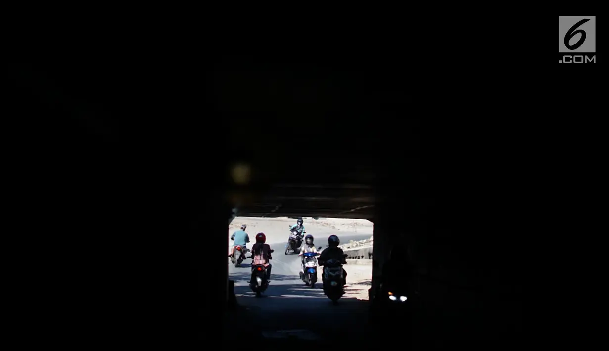 Pengendara motor melintasi terowongan di bawah Jalan Tol Jagorawi, kawasan Kampung Rambutan, Jakarta, Rabu (21/8/2019). Meskipun sempit dan gelap, namun terowongan itu menjadi akses alternatif pengguna jalan untuk menyeberangi Jalan Tol Jagorawi di kawasan tersebut. (Liputan6.com/Immanuel Antonius)