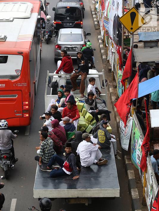 Pelajar menumpang truk terbuka yang melintas di kawasan Lenteng Agung, Jakarta, Senin (8/4). Perilaku buruk tersebut membahayakan keselamatan diri mereka dan pengguna jalan lain. (Liputan6.com/Immanuel Antonius)