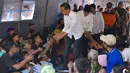 Presiden Joko Widodo atau Jokowi bersama Gubernur NTB Tuan Guru Bajang (TGB) Zainul Majdi menyapa warga saat mengunjungi korban gempa di lapangan Desa Madayin, Sambelia, Lombok Timur, NTB, Senin (30/7). (Agus Suparto/Indonesian Presidential Palace/AFP)