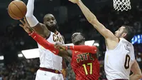 Duo Cleveland Cavaliers, LeBron James (kiri) dan Kevin Love (kanan), mengepung guard Atlanta Hawks Dennis Schroder pada laga NBA 2017-2018 di Philips Arena, Kamis (30/11/2017) atau Jumat (1/12/2017) WIB. (AP/Curtis Compton)