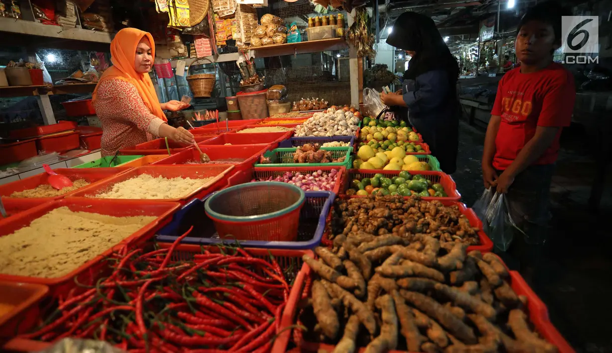 Pedagang melayani pembeli di pasar di Jakarta, Rabu (20/12).  Jelang Natal dan Tahun Baru, harga bahan pokok di Jakarta mulai merangkak naik. Namun, kenaikannya masih belum tinggi hanya berkisar Rp2.000-5.000 per kg. (Liputan6.com/Angga Yuniar)
