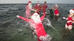 Sinterklas dari penjuru dunia menikmati bermain air laut Klampenborg di luar Kopenhagen, Denmark, Selasa (25/7). Lima bulan menjelang natal, ratusan Sinterklas berkumpul dalam Kongres Dunia Sinterklas yang ke 60. (Tobias Nicolai / Ritzau Foto via AP)