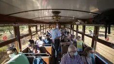 Inspektur Manolo Toncho berjalan melewati penumpang yang menaiki kereta Palma-Soller di Palma de Mallorca di Kepulauan Balearic Spanyol (14/7/2021). Diresmikan pada tahun 1912, jalur kereta api Palma-Soller adalah salah satu rute tertua yang masih beroperasi di Spanyol. (AFP/Jaime Reina)