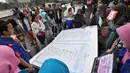 Sejumlah warga membaca Al-Quran raksasa saat Car Free Day di Bundaran HI, Jakarta, Minggu (8/2/2015). (Liputan6.com/Faizal Fanani)