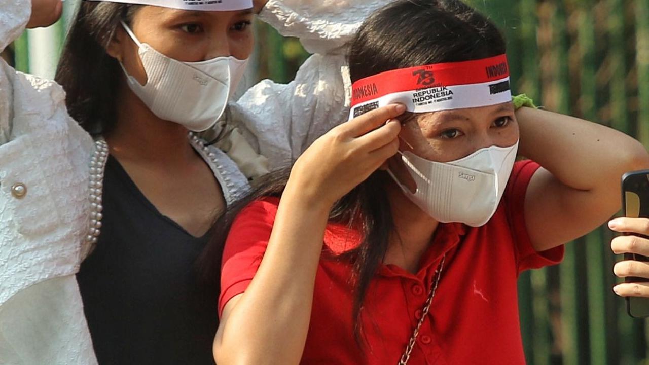 Sejumlah warga terlihat menyiapkan masker untuk dipakai selama mengikuti kirab. Ikat kain merah putih pun juga tak lupa mereka kenakan.
