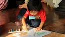 Salah satu anak menggambar di atas layang-layang buatannya di Museum Layang-Layang, Jakarta, (27/9/2014). (Liputan6.com/Helmi Fithriansyah)