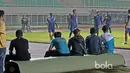 Pekerja beristirahat sejenak sambil menonton aksi para pemain Arema FC yang sedang berlatih di Stadion Pakansari, Bogor, Jumat (10/3/2017). Arema FC akan melawan Pusamania Borneo FC pada laga Final Piala Presiden 2017. (Bola.com/Nicklas Hanoatubun)