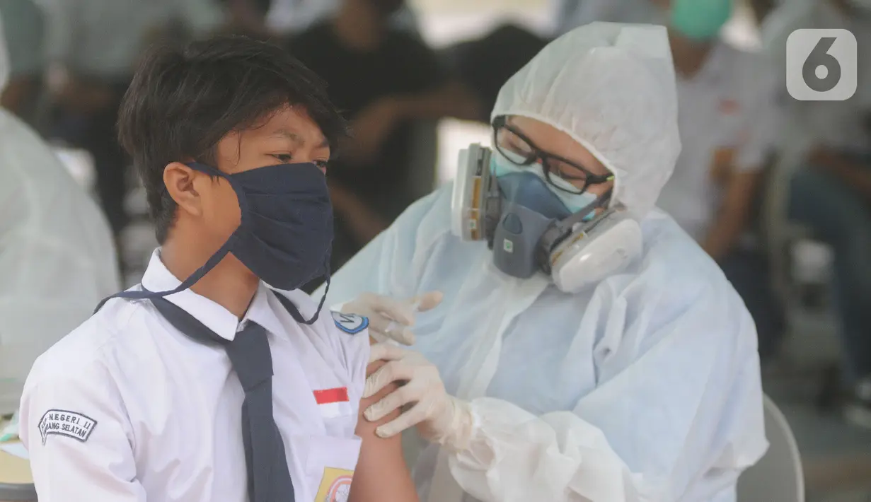 Paramedis memberikan suntikan vaksinasi kepada murid SMP di SMPN 11, Serpong, Tangerang Selatan, Rabu (14/072021). Dinas Kesehatan Tangerang Selatan menggelar vaksinasi COVID-19 perdana, Rabu (14/7/2021) dengan  menargetkan 1.000 pelajar. (merdeka.com/Arie Basuki)
