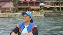 Menikmati suasana di Pulau Samosir, Junita Malau tidak melupakan jaket kesayangan. Jaket dual tone biru hitam dengan stripe orange itu ia kenakan melapisi t-shirt berwarna hijau muda dan celana pendek. (instagram/junita_malau)