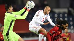Kiper Belgia, Thibaut Courtois, berusaha menangkap bola saat menghadapi Denmark pada laga lanjutan UEFA Nations League di Stadion Den Dreef, Kamis (19/11/2020) dini hari WIB. Belgia menang 4-2 atas Denmark. (AFP/John Thys)