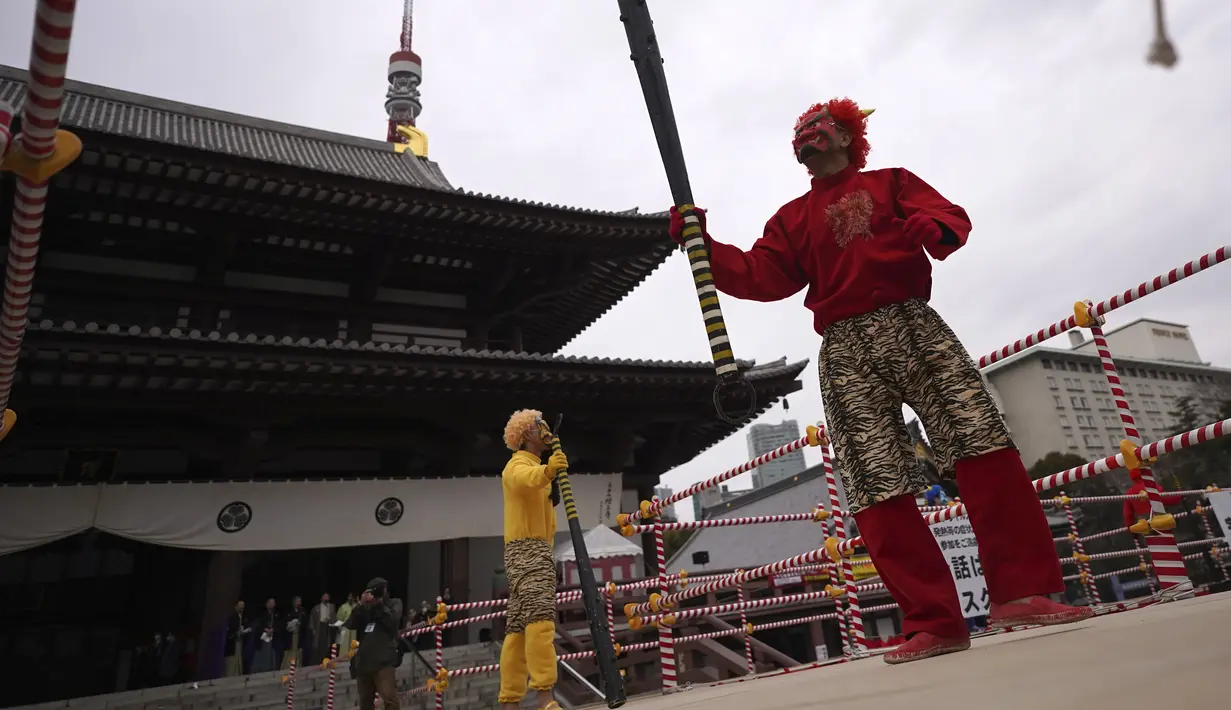 Para penari yang berperan sebagai setan menari selama "Mame-maki", upacara melempar kacang, di kuil Buddha Zojoji, Tokyo, Jumat (3/2/2023). Sebagai kacang keberuntungan, tidak hanya dilempar untuk mengusir roh jahat, warga biasanya akan memakan satu kacang setiap tahunnya. (AP Photo/Eugene Hoshiko)