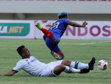 Striker Arema FC, Kushedya Hari Yudo, terjatuh saat berebut bola dengan gelandang Persikabo 1973, Wawan Febriyanto dalam laga pembuka Piala Menpora 2021 di Stadion Manahan, Solo, Minggu (21/3/2021). Arema FC bermain Imbang 1-1 dengan Persikabo 1973. (Bola.com/M Iqbal Ichsan)