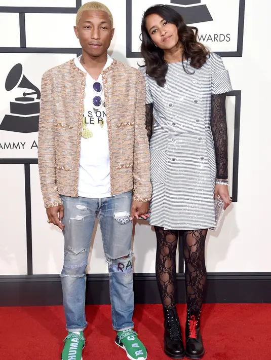 Pharrell Williams dan istrinya, Helen Lasichanh, berpose di karpet merah Grammy Awards 2016 di Los Angeles, Senin (15/2). Rapper 42 tahun itu mengenakan jeans beraksen sobekan dipadukan jaket coklat tak berkerah. (Jason Merritt/Getty Images for NARAS/AFP)
