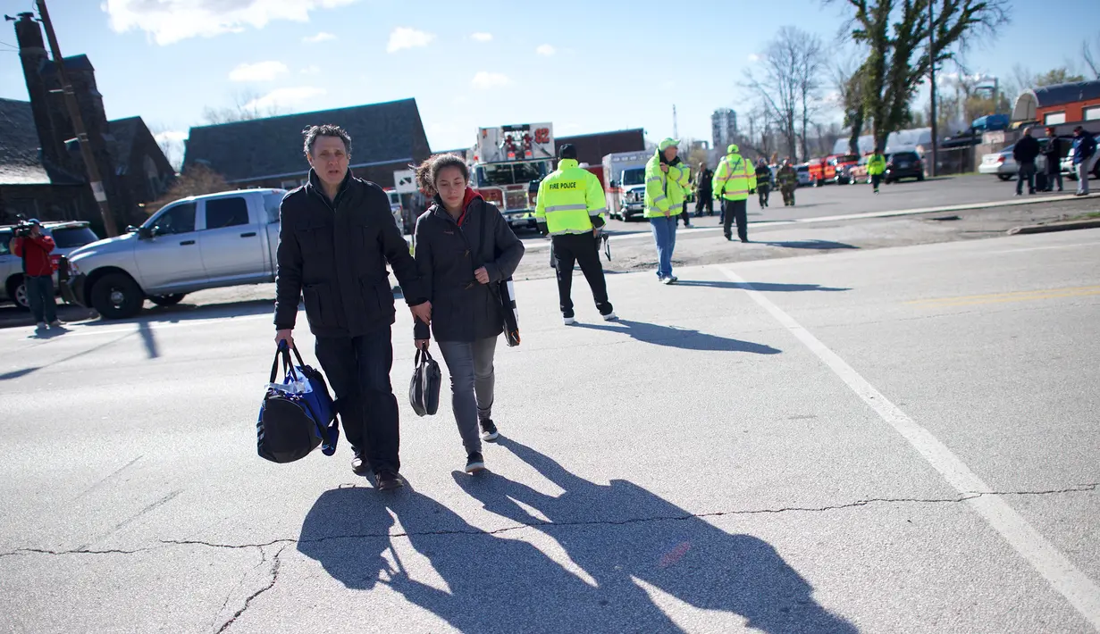 Seorang ayah menjemput putrinya yang menjadi korban dari kecelakaan kereta Amtrak yang menabrak sebuah backhoe di dekat Philadelphia, Amerika Serikat, Minggu (3/4). Sedikitnya dua orang tewas akibat kejadian ini. (Mark Makela/Getty Images/AFP)