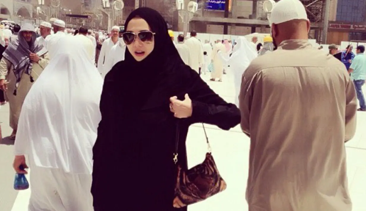 Ketika menjalani ibadah umrah beberapa waktu lalu, begini gaya Aura Kasih dengan busana serba hitam. Ia tampak begitu anggun mengenakan gamis berwarna hitam yang dipadukan dengan hijab senada. (Liputan6.com/IG/@aurakasih)