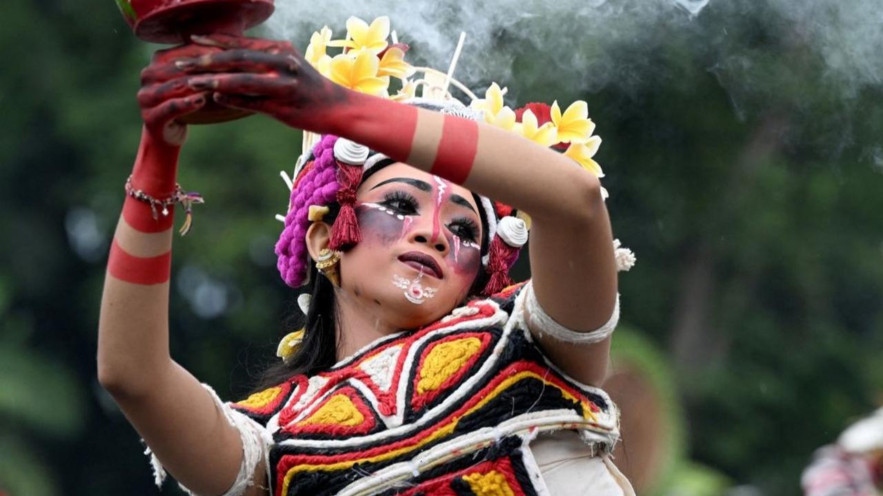 Masyarakat Bali tampil membawakan tarian tadisional saat mengikuti ritual dalam parade patung Ogoh-Ogoh yang melambangkan roh jahat, sebelum perayaan Hari Nyapi digelar di Denpasar, Bali. Foto: AFP / SONNY TUMBELAKA<br>