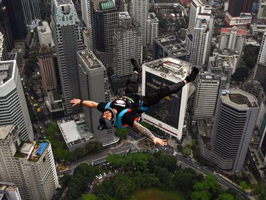 Penerjun Australia Chris Mcdougall melompat dari dek terbuka Menara Kuala Lumpur saat International Tower Jump, Kuala Lumpur, Malaysia, 3 Februari 2023. Lebih dari 100 penerjun melompat dari Menara Kuala Lumpur setinggi 300 meter yang terkenal tersebut. (MOHD RASFAN/AFP)