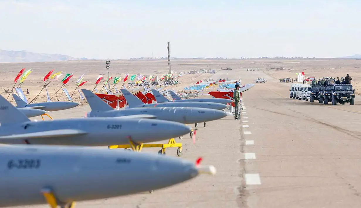 Pejabat militer memeriksa drone yang dipamerkan sebelum latihan drone militer di lokasi yang dirahasiakan di Iran tengah (5/1/2021). Drone-drone buatan Persia itu akan melakukan pertempuran, pengawasan, pengintaian, dan peperangan elektronik dalam penerbangan jarak pendek dan jauh. (Army office/AFP)