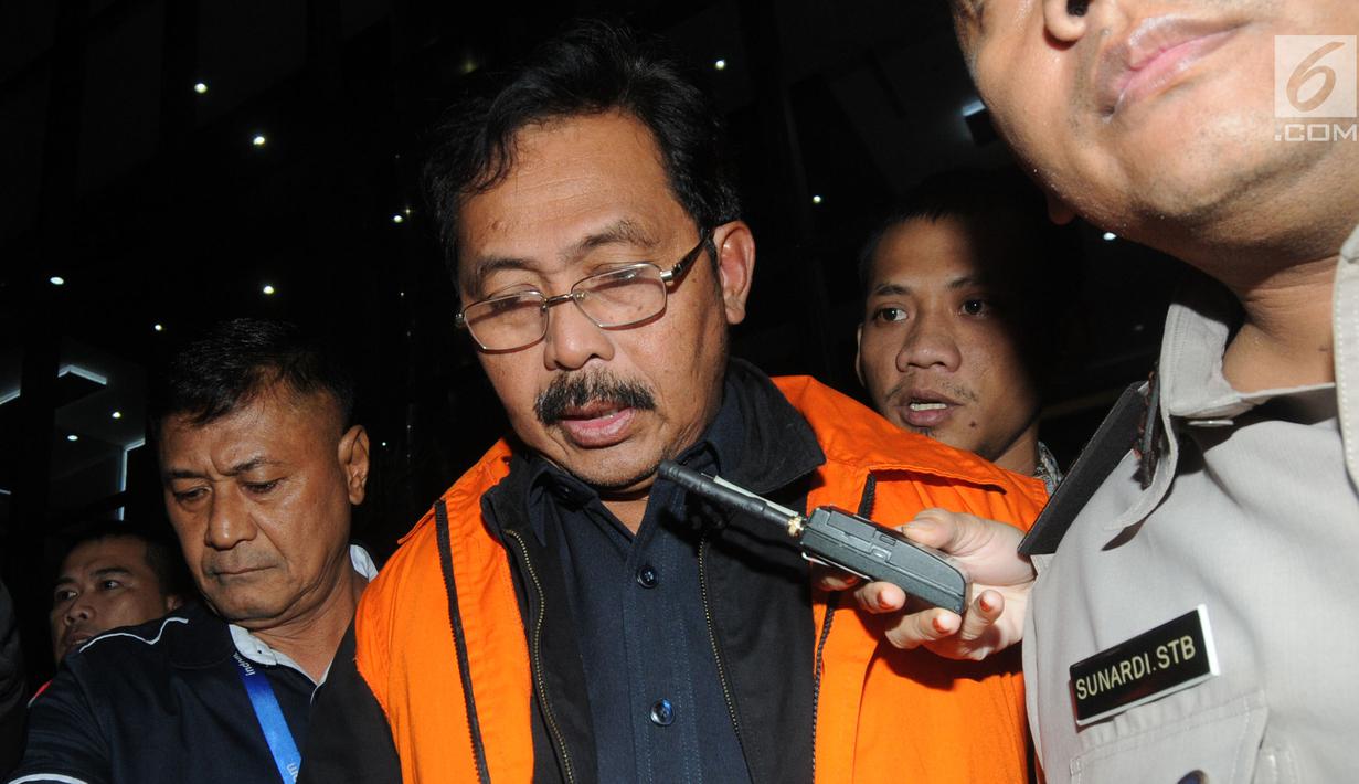 Gubernur Kepri Nurdin Basirun dikawal petugas usai menjalani pemeriksaan 1 x 24 jam di Gedung KPK, Jakarta, Jumat dini hari (12/7/2019). Nurdin Basirun resmi ditahan KPK bersama tiga tersangka dengan barang bukti berbagai pecahan mata uang senilai Rp666.812.189,56. (merdeka.com/Dwi Narwoko)