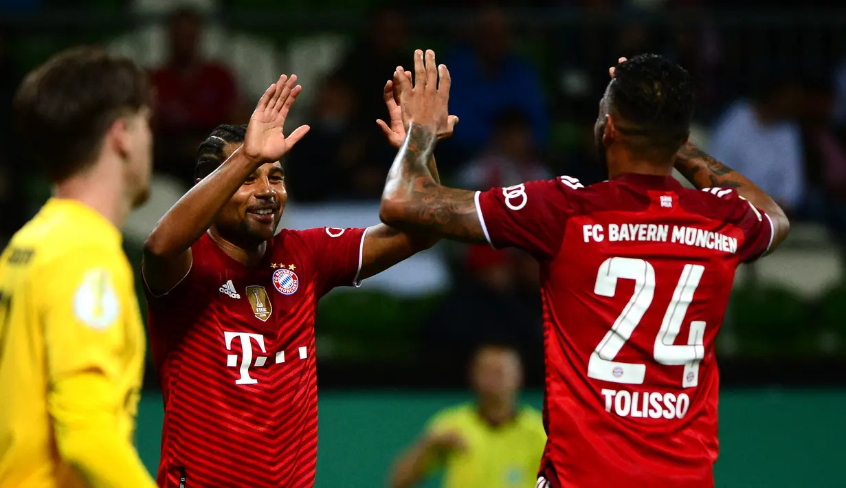Gelandang Bayern Munchen, Corentin Tolisso berselebrasi dengan rekannya Serge Gnabry usai mencetak gol ke gawang Bremen SV dalam laga putaran pertama DFB Pokal 2021-22 di Bremen, Jerman utara (25/8/2021). Munchen menang telak atas Bremen SV dengan skor 12-0. (AFP/Patrik Stollarz)