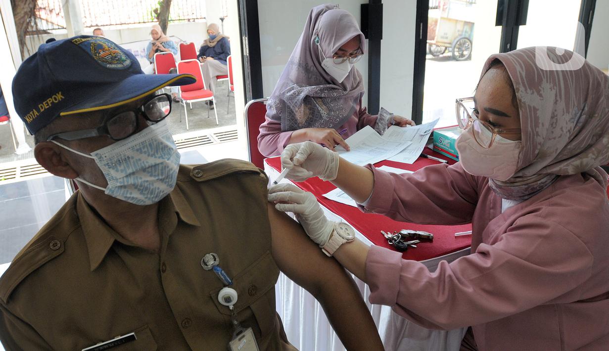 Paramedis memberikan vaksin booster saat pelaksanaan vaksinasi serentak Pemkot Depok di Kantor Kecamatan Cinere, Depok, Senin (18/4/20222). Gebyar vaksinasi booster secara massal ini bertujuan memberikan kemudahan bagi warga sebelum melakukan perjalanan mudik lebaran 2022. (merdeka.com/Arie Basuki)