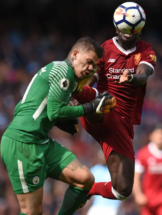 Kaki Mane menghantam tepat di wajah kiper Manchester City, Ederson saat pertandingan Liga Inggris di Stadion Etihad, Manchester (9/9). Usai hantaman, Ederson langsung mendapat perawatan hingga ditandu ke luar lapangan. (AFP Photo/Oli Scarff)