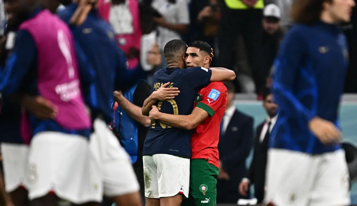 Penyerang Prancis Kylian Mbappe dan bek Maroko Achraf Hakimi saling menyapa pada akhir babak semifinal Piala Dunia 2022 di Al Bayt Stadium, Kamis (15/12/2022) dini hari WIB. Laga Perancis vs Maroko menjadi pertemuan antara dua pemain Paris Saint-Germain (PSG), Kylian Mbappe dan Achraf Hakimi. (GABRIEL BOUYS / AFP)